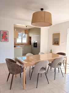 a kitchen and dining room with a wooden table and chairs at Maison de la plage - Dossen Santec - Réservations à la semaine, de week-ends en week-ends in Santec