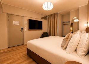a hotel room with a large bed and a television at De Herbert Amsterdam - Formerly France Hotel in Amsterdam