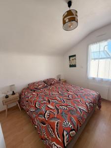 a bedroom with a bed with a colorful comforter at Maison de la plage - Dossen Santec - Réservations à la semaine, de week-ends en week-ends in Santec +39 photos