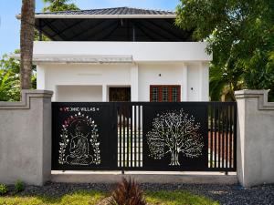a house with a gate with a tree painted on it at Vedic villa Cherai beach in Cochin
