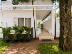 a house with a wooden bench and palm trees at Vedic villa Cherai beach in Cochin