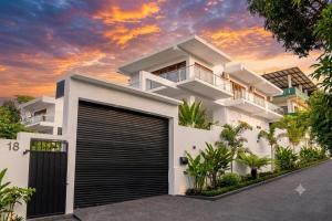 a white house with a garage at sunset at Waypoint Resort and Apartments in Hikkaduwa