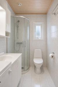 a white bathroom with a shower and a toilet at Rønsholmen brygger in Beian