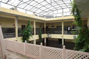a building with a balcony with plants and a glass ceiling at Shree Krishna Hotel & Restraunt in Pātolī