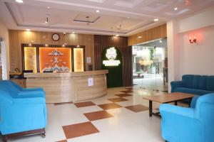 a waiting room with blue chairs and a counter at Shree Krishna Hotel & Restraunt in Pātolī