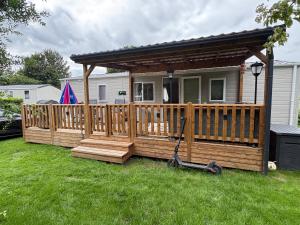 a house with a wooden deck with a mower at Distel&Meer in Kropswolde