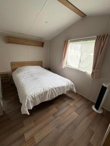 a bedroom with a white bed and a window at Distel&Meer in Kropswolde