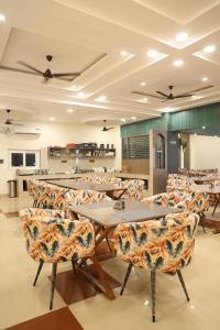 a restaurant with tables and chairs in a room at Shree Krishna Hotel & Restraunt in Pātolī
