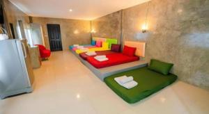 a living room with a colorful couch and a refrigerator at The Rest Hotel in Ko Larn