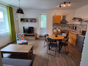 a living room with a table and a kitchen at Apartmán Wake u aquaparku in Česká Lípa