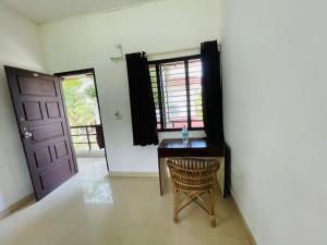 a room with a desk and a door and a chair at Sea Mist Beach Villas Alleppey in Alleppey