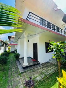 a view of a white house with a porch at Sea Mist Beach Villas Alleppey in Alleppey +33 photos