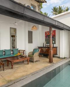a patio with couches and a table and a piano at udesh hotel in Minuwangoda