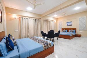 a bedroom with two beds and a table and chairs at FabHotels Norvia in New Delhi