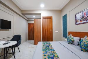 a hotel room with a bed and a table and a tv at FabHotels Norvia in New Delhi