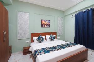 a bedroom with a large bed with blue walls at FabHotels Norvia in New Delhi