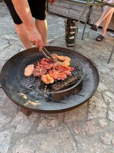 a person is cooking meat on a grill at Sentio Inn 2 in Dunajská Streda
