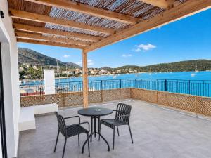 a patio with a table and chairs and a view of the water at Dolphin hotel in Korfos