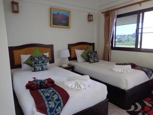 two beds in a room with a window at Namkhong Riverside in Chiang Khong