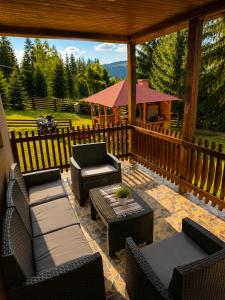 a patio with chairs and tables and a gazebo at Casa Dragomir in Plaiu Şarului