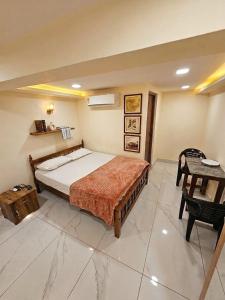 a bedroom with a bed and a table in it at Tvm stays in Trivandrum +3 photos