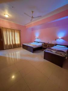 a large room with two beds and purple lighting at Tvm stays in Trivandrum