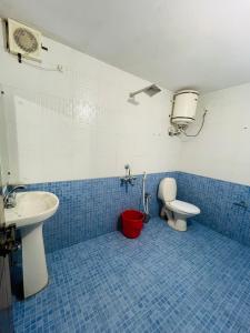 a blue tiled bathroom with a toilet and a sink at Sea Mist Beach Villas Alleppey in Alleppey