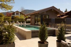a swimming pool in front of a house at Hotel Alpenhof in Bad Wiessee