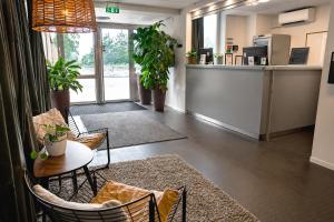 an office lobby with a table and chairs and a counter at Biz Apartment Solna in Solna