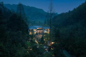 a large house in the middle of a forest at night at 不宿 久之森林私汤民宿 BuSu Forest Forever Hotel in Jiezi Ancient Town