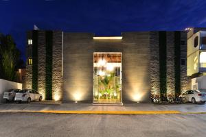 a building with two cars parked in front of it at Elements Tulum Boutique Hotel in Tulum