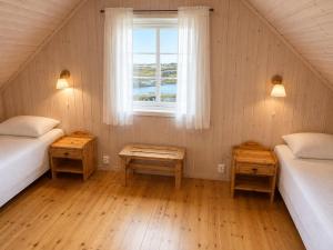 a attic room with two beds and a window at Rønsholmen brygger in Beian