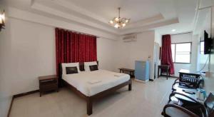 a bedroom with a bed and a desk in a room at Erawan Place in Mae Sot