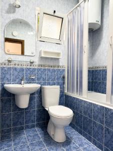 a blue tiled bathroom with a toilet and a sink at Lyon Apartments in Budva +38 photos
