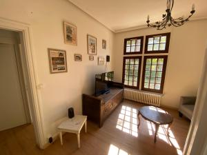 a living room with a table and a chair at Domaine Lainault - Logement des Vignerons in Lhomme