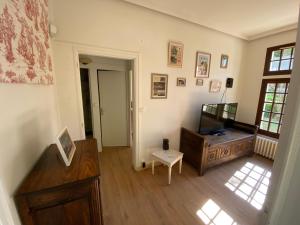 a living room with a television and a table at Domaine Lainault - Logement des Vignerons in Lhomme