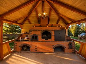 an outdoor kitchen with a brick oven in a pavilion at Casa Dragomir in Plaiu Şarului