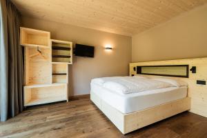 a bedroom with a bed and a flat screen tv at Agriturismo Maso Loera in Pelugo