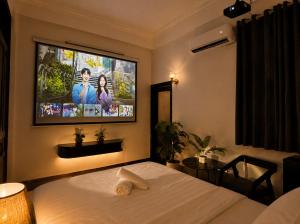 a bedroom with a bed and a tv on the wall at Moonland Hotel in Phương Lăng