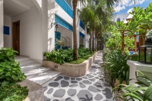 a walkway with palm trees and plants at Risemount Premier Resort Da Nang in Danang