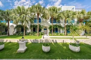 a large white building with palm trees in front of it at Risemount Premier Resort Da Nang in Danang