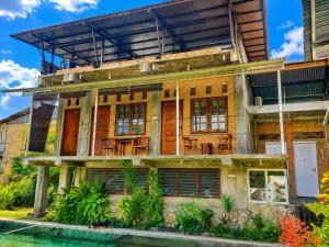 an old building with a pool in front of it at Kaliele House in Domine Eduard Osok Airport