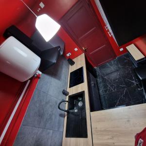an overhead view of a small kitchen with red cabinets at Le Ratna in Groslay