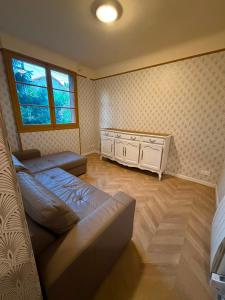a bedroom with a bed and a dresser and a window at Le Ratna in Groslay