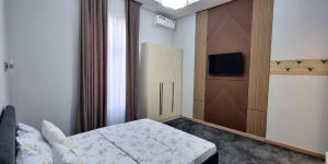a small bedroom with a bed and a television at Maftun Guest House in Samarkand