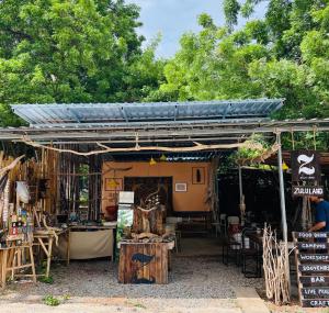 a store with awning and tables and chairs in front at Zulu land Kohlarn in Ko Lan