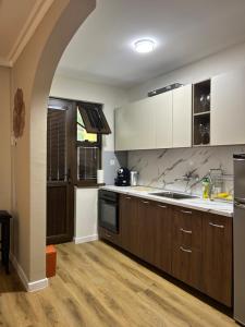 a kitchen with wooden cabinets and an archway at Къща Петя село Орешак in Troyan