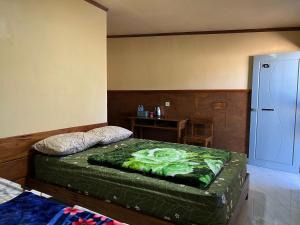 a bedroom with a bed and a table in it at Tengger Indah Seruni Bromo in Probolinggo