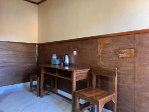 a wooden table with two chairs and a telephone at Tengger Indah Seruni Bromo in Probolinggo