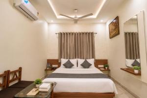 a bedroom with a large bed and a window at Hotel Bhakti Rajkot I Hotel in Rajkot I Best Hotel in Rajkot in Rajkot